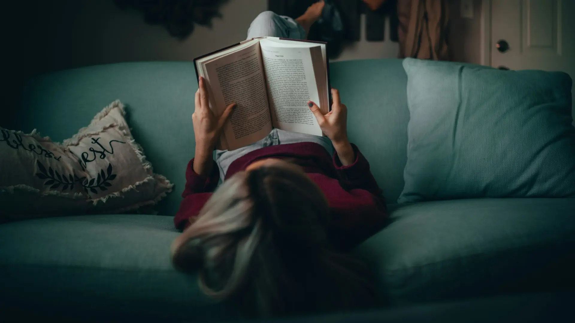 Una mujer, vestida de rojo, leyendo un libro